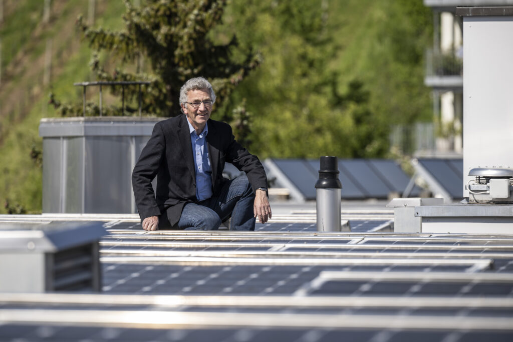 Mann sitzt auf Photovoltaikanlage